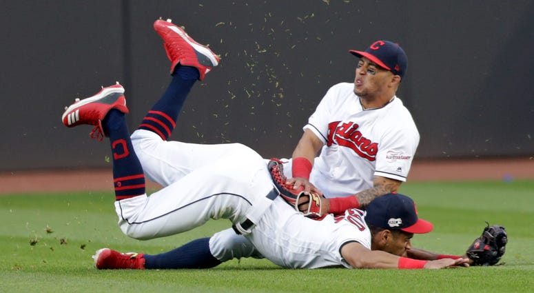 Cleveland Indians' Leonys Martin, top, and Oscar Mercado collide while going after a ball hit by Tampa Bay Rays' Kevin Kiermaier during the sixth inning of a baseball game Thursday, May 23, 2019, in Cleveland. Kiermaier hit a three-run home run.