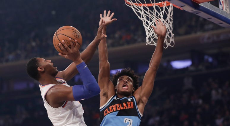 New York Knicks' RJ Barrett, left, drives past Cleveland Cavaliers' Collin Sexton, right, during the first half of an NBA basketball game Monday, Nov. 18, 2019, in New York.