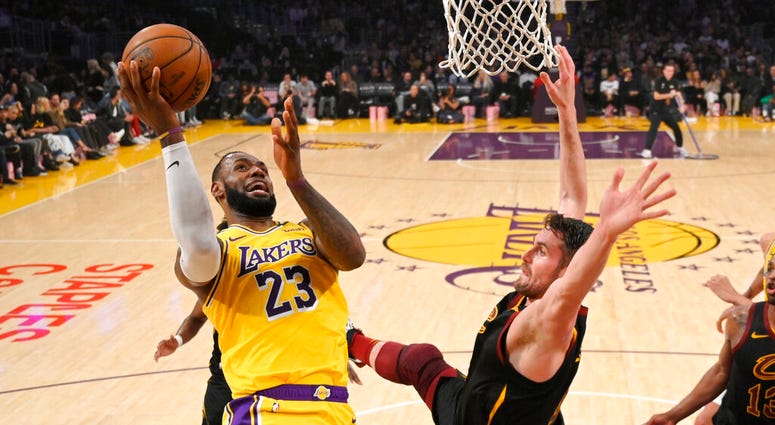 Los Angeles Lakers forward LeBron James, left, shoots as Cleveland Cavaliers forward Kevin Love defends during the first half of an NBA basketball game Monday, Jan. 13, 2020, in Los Angeles. (AP Photo/Mark J. Terrill)