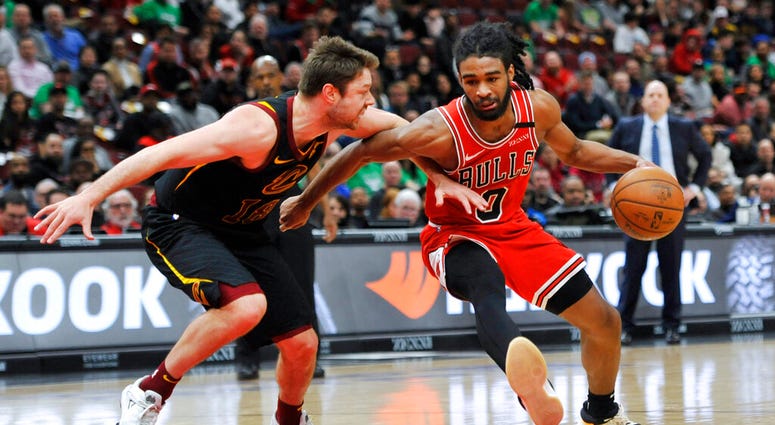 Chicago Bulls' Coby White (0) drives against Cleveland Cavaliers' Cedi Osman (16) during the second half of an NBA basketball game Tuesday, March 10, 2020, in Chicago. (AP Photo/Paul Beaty)