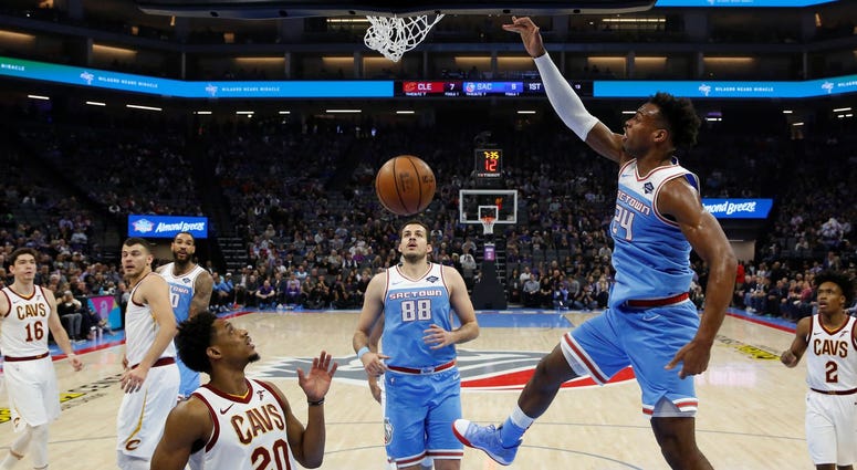 Sacramento Kings guard Buddy Hield dunks over Cleveland Cavaliers guard Brandon Knight (20) during the first quarter of an NBA basketball game Thursday, April 4, 2019, in Sacramento, Calif.