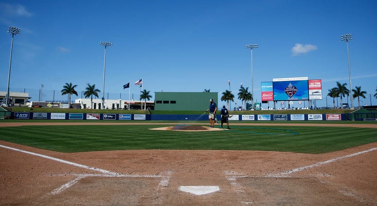 VARIOUS CITIES, - MARCH 12: Grounds crew workers clean up the field after the Grapefruit League spring training game between the Washington Nationals and the New York Yankees at FITTEAM Ballpark of The Palm Beaches on March 12, 2020 in West Palm Beach, Fl