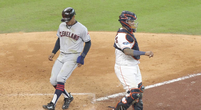 Cleveland Indians shortstop Francisco Lindor (left) scores on a ground out by second baseman Jose Ramirez (not pictured) against Houston Astros catcher Martin Maldonado (right) during the sixth inning in game one of the 2018 ALDS at Minute Maid Park Francisco Lindor scores in Game 1 ALDS