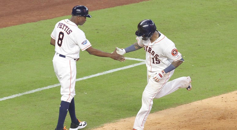 Houston Astros catcher Martin Maldonado (15) is congratulated by third base coach Gary Pettis (8) for hitting a solo home run during the seventh inning in game one of the 2018 ALDS playoff baseball series against the Cleveland Indians at Minute Maid Park. Martin Maldonado HR Game 1 ALDS