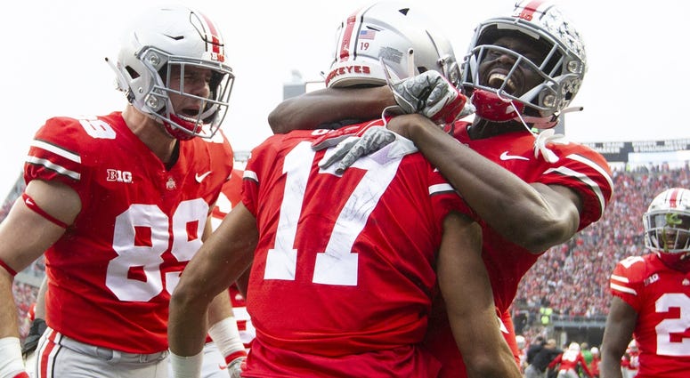 Ohio State Buckeyes wide receiver Chris Olave (17) is congratulated by tight end Luke Farrell (89) and wide receiver Binjimen Victor (9) after scoring a touchdown against the Michigan Wolverines at Ohio Stadium. Chris Olave Luke Farrell Ohio State