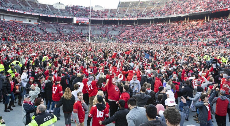 Ohio State Buckeyes fans swarm the field after a victory over the Michigan Wolverines at Ohio Stadium