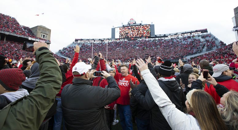Ohio State Buckeyes fans swarm the field after a victory over the Michigan Wolverines at Ohio Stadium.