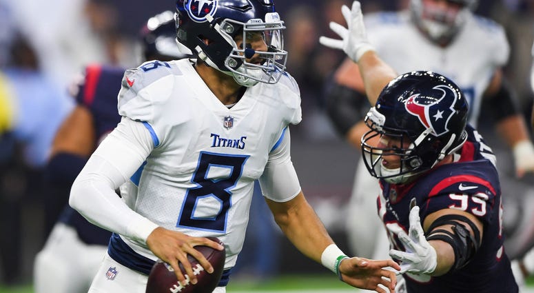 Tennessee Titans quarterback Marcus Mariota (8) looks to pass the ball as Houston Texans defensive end J.J. Watt (99) defends during the second quarter at NRG Stadium.