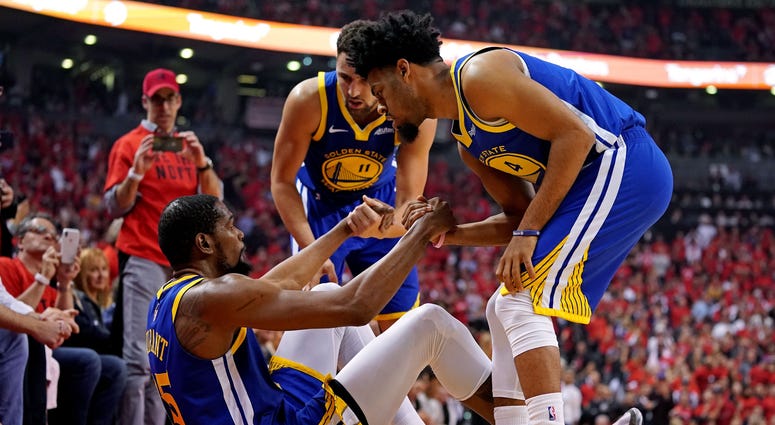Golden State Warriors forward Kevin Durant (35) is helped up by guard Quinn Cook (4) and guard Klay Thompson (11) after an apparent injury during the second quarter in game five of the 2019 NBA Finals against the Toronto Raptors at Scotiabank Arena. Golden State Warriors forward Kevin Durant (35) is helped up by guard Quinn Cook (4) and guard Klay Thompson (11) after an apparent injury during the second quarter in game five of the 2019 NBA Finals against the Toronto Raptors at Scotiabank Arena.