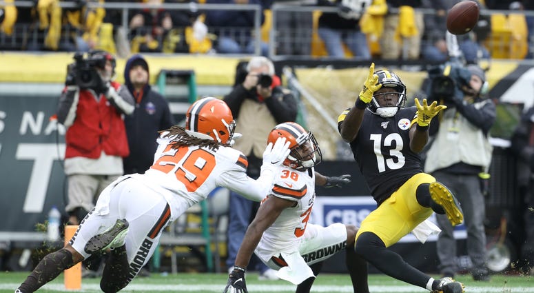 Pittsburgh Steelers wide receiver James Washington (13) catches a touchdown pass against Cleveland Browns defensive back T.J. Carrie (38) and defensive back Sheldrick Redwine (29) during the second quarter at Heinz Field. James Washington Pittsburgh Steelers Cleveland Browns