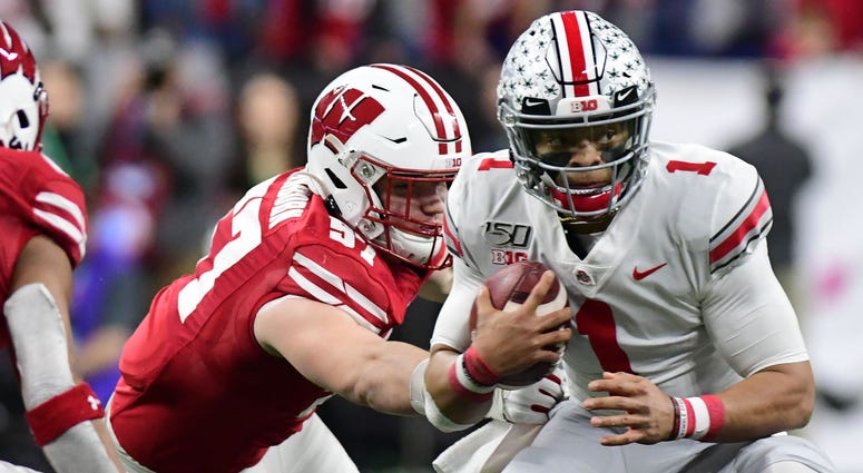 Dec 7, 2019; Indianapolis, IN, USA; Ohio State Buckeyes quarterback Justin Fields (1) runs out of the pocket and is tackled by Wisconsin Badgers defensive end Noah Potter (97) during the first half in the 2019 Big Ten Championship Game at Lucas Oil Stadiu Ohio State quarterback Justin Fields