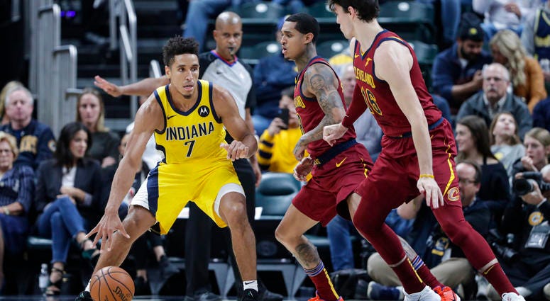 Indiana Pacers guard Malcolm Brogdon (7) drives on Cleveland Cavaliers guard Jordan Clarkson and forward Cedi Osman (16) during the second half of an NBA basketball game in Indianapolis, Friday, Nov. 1, 2019. Indiana Pacers guard Malcolm Brogdon (7) drives on Cleveland Cavaliers guard Jordan Clarkson and forward Cedi Osman (16)