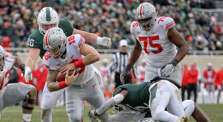 Ohio State Buckeyes quarterback Tate Martell (18) is tripped up by Michigan State Spartans cornerback Justin Layne (2) during the first half of a game at Spartan Stadium. Ohio State Buckeyes quarterback Tate Martell (18) is tripped up by Michigan State Spartans cornerback Justin Layne (2) during the first half of a game at Spartan Stadium.