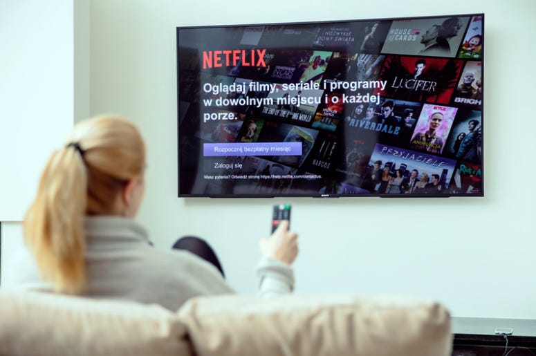 Woman is using Netflix application on her TV in Europe. WROCLAW, POLAND - APRIL 03rd, 2018: Netflix is an american entertainment company specialized in streaming media.