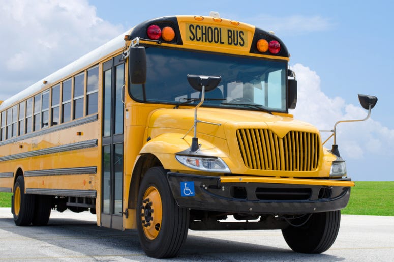 Yellow school bus on the blacktop on a beautiful sunny day Yellow school bus on the blacktop on a beautiful sunny day