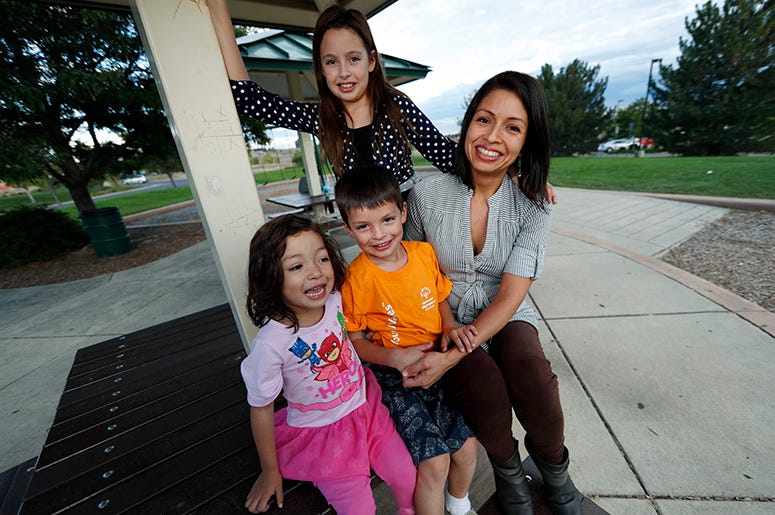 En esta fotografía del 2 de octubre de 2018, Laura Peniche, derecha, está con sus tres hijos, Katalina de 11 años, atrás izquierda, Athena, de 4 años, frente derecha, y Leonardo de 6 años en el patio de juegos en el suburbio Thornton de Denver, Dolorado. En esta fotografía del 2 de octubre de 2018, Laura Peniche, derecha, está con sus tres hijos, Katalina de 11 años, atrás izquierda, Athena, de 4 años, frente derecha, y Leonardo de 6 años en el patio de juegos en el suburbio Thornton de Denver, Dolorado.