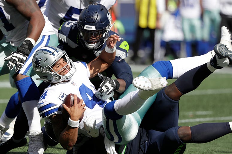 En esta foto del 23 de septiembre de 2018, el quarterback Dak Prescott (4) de los Cowboys de Dallas es derribado por Dion Jordan y Jarran Reed (en el piso) de los Seahawks de Seattle. En esta foto del 23 de septiembre de 2018, el quarterback Dak Prescott (4) de los Cowboys de Dallas es derribado por Dion Jordan y Jarran Reed (en el piso) de los Seahawks de Seattle.