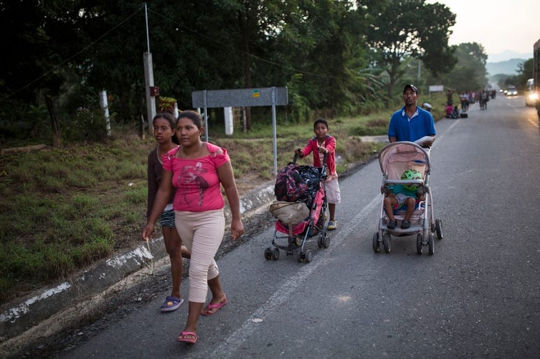 La familia Espinar camina por una carretera que une Pijijiapan con Arriaga, la próxima parada de la caravana de migrantes centroamericanos que viaja hacia la frontera con Estados Unidos, en México, el 26 de octubre de 2018. La familia procede de La Conce, La familia Espinar camina por una carretera que une Pijijiapan con Arriaga, la próxima parada de la caravana de migrantes centroamericanos que viaja hacia la frontera con Estados Unidos, en México, el 26 de octubre de 2018. La familia procede de La Conce,