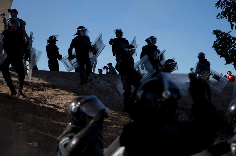 Policías mexicanos intentan impedir que un grupo de migrantes centroamericanos se desplace más allá del cruce fronterizo Chaparral en Tijuana, México, el domingo 25 de noviembre de 2018. Policías mexicanos intentan impedir que un grupo de migrantes centroamericanos se desplace más allá del cruce fronterizo Chaparral en Tijuana, México, el domingo 25 de noviembre de 2018.