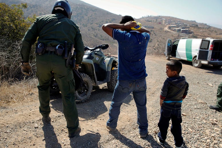 Un guatemalteco y su hijo son detenidos por agentes de la Patrulla de Fronteras tras cruzar la frontera entre México y Estados Unidos ilegalmente en San Diego el 28 de junio del 2018. Un guatemalteco y su hijo son detenidos por agentes de la Patrulla de Fronteras tras cruzar la frontera entre México y Estados Unidos ilegalmente en San Diego el 28 de junio del 2018.