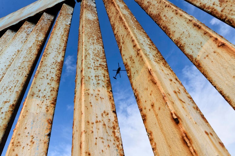 Un helicóptero monitorea la cerca fronteriza de Estados Unidos, visto desde Tijuana, México, el domingo 23 de diciembre de 2018. Un helicóptero monitorea la cerca fronteriza de Estados Unidos, visto desde Tijuana, México, el domingo 23 de diciembre de 2018.