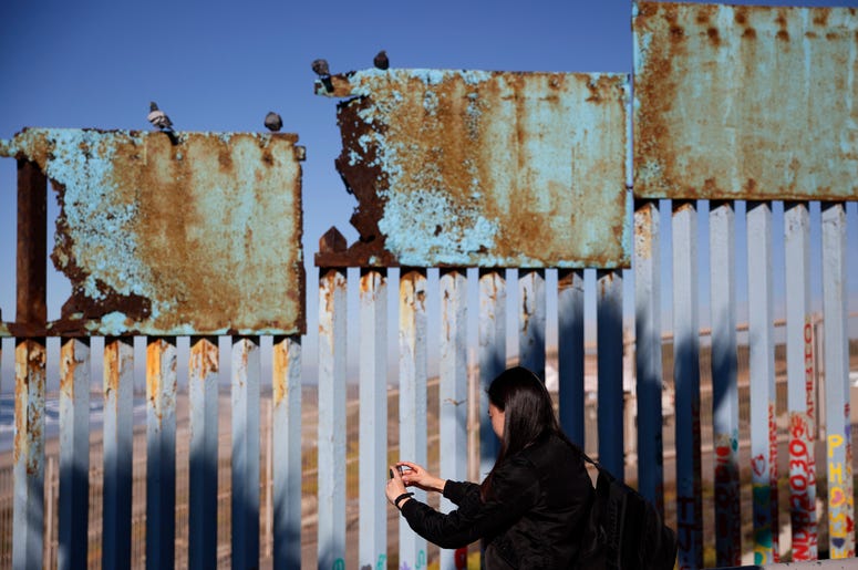 Una mujer toma fotos de un tramo herrumbrado del muro fronterizo entre EEUU y México cerca de Tijuana, México, el 7 de enero del 2019. Una mujer toma fotos de un tramo herrumbrado del muro fronterizo entre EEUU y México cerca de Tijuana, México, el 7 de enero del 2019.
