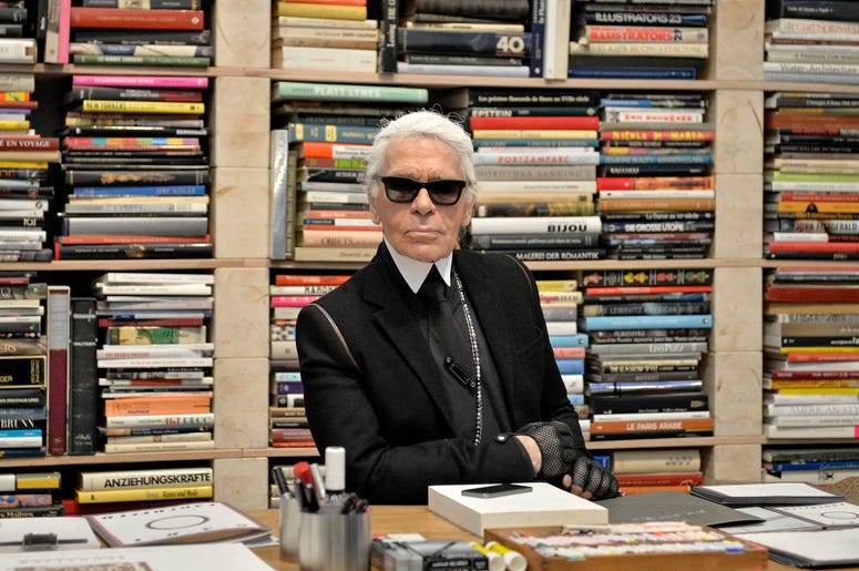 Fotografía de archivo del 14 de febrero de 2014 del diseñador de modas Karl Lagerfeld frente a sus libros antes de la inauguración de una exhibición en el museo Folkwang en Essen, Alemania. Fotografía de archivo del 14 de febrero de 2014 del diseñador de modas Karl Lagerfeld frente a sus libros antes de la inauguración de una exhibición en el museo Folkwang en Essen, Alemania.