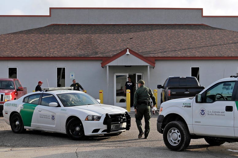 En esta fotografía de archivo del 23 de junio de 2018, un agente de la Patrulla Fronteriza camina entre vehículos afuera del Centro Principal de Procesamiento en McAllen, Texas. En esta fotografía de archivo del 23 de junio de 2018, un agente de la Patrulla Fronteriza camina entre vehículos afuera del Centro Principal de Procesamiento en McAllen, Texas.