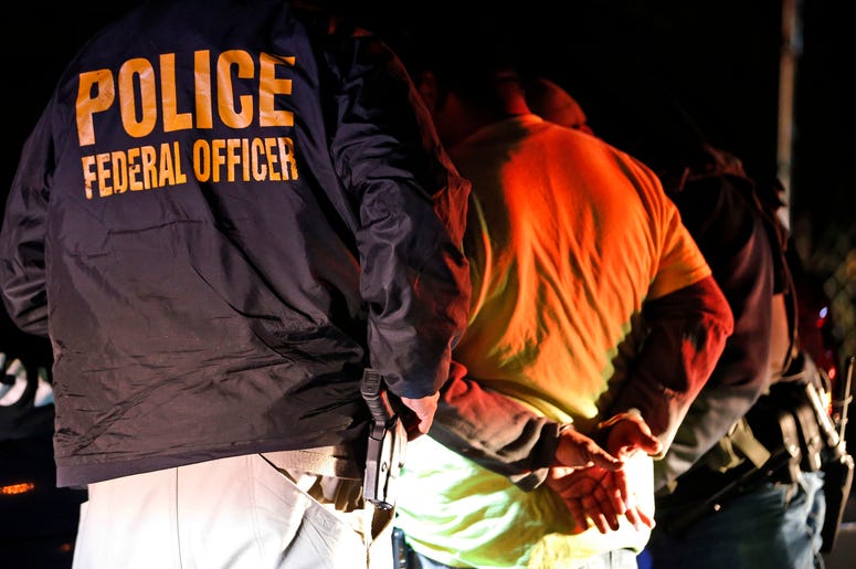 En esta fotografía de archivo del 22 de octubre de 2018, agentes del Servicio de Control de Inmigración y Aduanas detienen a una persona durante una redada en Richmond, Virginia. En esta fotografía de archivo del 22 de octubre de 2018, agentes del Servicio de Control de Inmigración y Aduanas detienen a una persona durante una redada en Richmond, Virginia.