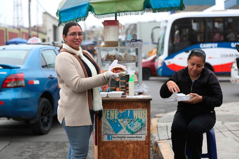 En esta imagen del 12 de junio de 2019, la vendedora de arepas venezolana Yuleiny Mendoza posa para una foto en su puesto de arepas en una esquina de Lima, Per . En esta imagen del 12 de junio de 2019, la vendedora de arepas venezolana Yuleiny Mendoza posa para una foto en su puesto de arepas en una esquina de Lima, Per .