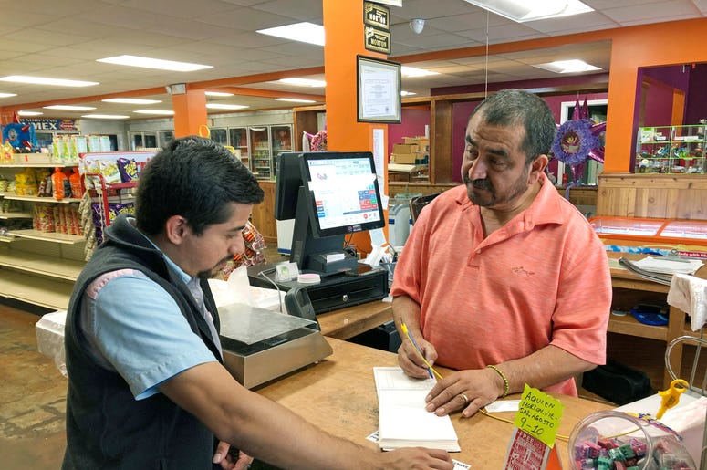 Fotografía del jueves 8 de agosto de 2019 de Juan García, derecha, atendiendo a un cliente en su tienda Hondumex en el centro de Morton, Mississippi. Fotografía del jueves 8 de agosto de 2019 de Juan García, derecha, atendiendo a un cliente en su tienda Hondumex en el centro de Morton, Mississippi.