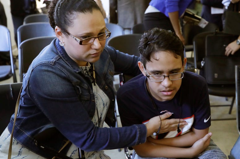 La hondureña Mariela Sánchez consuela a su hijo Jonathan, de 16 años, durante una conferencia de prensa, el lunes 26 de agosto del 2019 en Boston. La familia Sánchez viajó a Estados Unidos en busca de tratamiento médico para Jonathan, quien sufre de fibro La hondureña Mariela Sánchez consuela a su hijo Jonathan, de 16 años, durante una conferencia de prensa, el lunes 26 de agosto del 2019 en Boston. La familia Sánchez viajó a Estados Unidos en busca de tratamiento médico para Jonathan, quien sufre de fibro