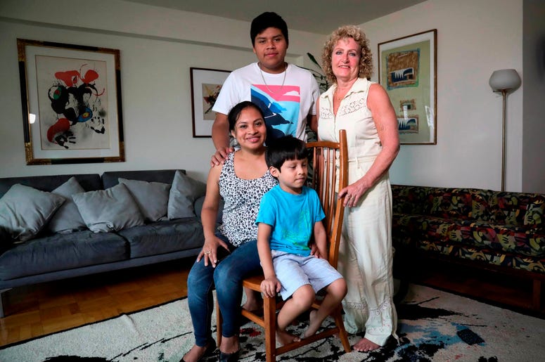 En esta foto del miércoles 21 de agosto de 2019, la inmigrante guatemalteca Rosayra Pablo Cruz, a la izquierda, y sus hijos Yordy, de 17 años, y Fernando, de 6, posan con su anfitriona Vivien Tartter, una profesora universitaria que abrió su hogar a la fa En esta foto del miércoles 21 de agosto de 2019, la inmigrante guatemalteca Rosayra Pablo Cruz, a la izquierda, y sus hijos Yordy, de 17 años, y Fernando, de 6, posan con su anfitriona Vivien Tartter, una profesora universitaria que abrió su hogar a la fa