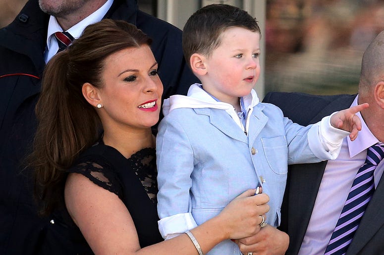 En imagen de archivo del sábado 6 de abril de 2013, Coleen Rooney, izquierda, esposa del futbolista inglés Wayne Rooney, y su hijo Kai, derecha, en Aintree Racecourse, Liverpool, Inglaterra. En imagen de archivo del sábado 6 de abril de 2013, Coleen Rooney, izquierda, esposa del futbolista inglés Wayne Rooney, y su hijo Kai, derecha, en Aintree Racecourse, Liverpool, Inglaterra.