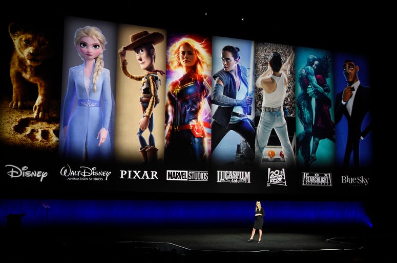 En esta foto del 3 de abril de 2019, personajes de cintas de Disney y Fox se proyectan detrás de Cathleen Taff, una ejecutiva de Walt Disney Studios, durante la presentación de Walt Disney Studios Motion Pictures en CinemaCon 2019 en Las Vegas. Verizon es En esta foto del 3 de abril de 2019, personajes de cintas de Disney y Fox se proyectan detrás de Cathleen Taff, una ejecutiva de Walt Disney Studios, durante la presentación de Walt Disney Studios Motion Pictures en CinemaCon 2019 en Las Vegas. Verizon es