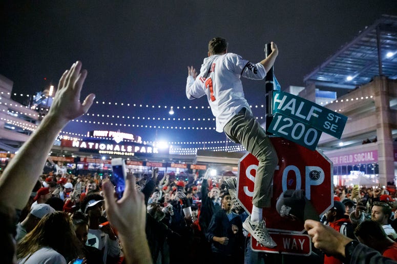 Un aficionado de los Nacionales de Washington escala un poste a las afueras de Nationals Park a primeras horas del jueves 31 de octubre de 2019, en Washington, después de que los Nacionales derrotaron a los Astros de Houston en el séptimo juego de la Seri Un aficionado de los Nacionales de Washington escala un poste a las afueras de Nationals Park a primeras horas del jueves 31 de octubre de 2019, en Washington, después de que los Nacionales derrotaron a los Astros de Houston en el séptimo juego de la Seri