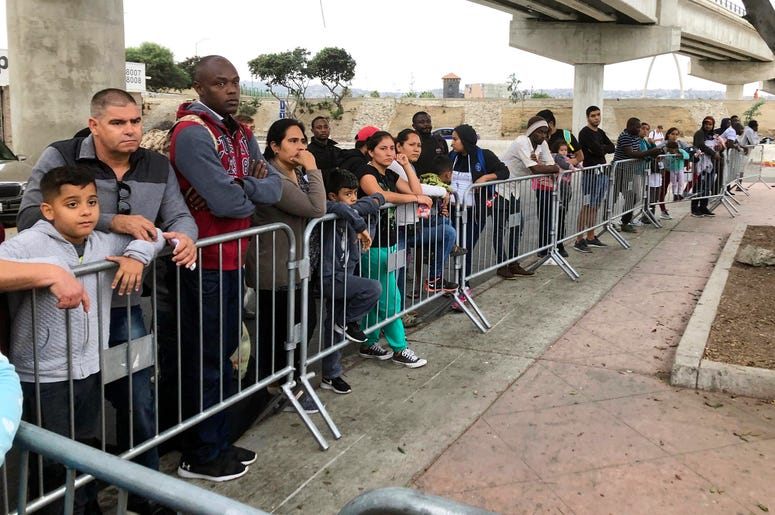 En esta fotografía del 26 de septiembre de 2019, solicitantes de asilo en Tijuana, México, esperan ser nombrados de una lista de espera en un cruce fronterizo en San Diego. En esta fotografía del 26 de septiembre de 2019, solicitantes de asilo en Tijuana, México, esperan ser nombrados de una lista de espera en un cruce fronterizo en San Diego.