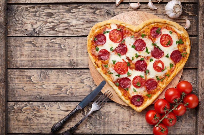Heart shaped pizza with pepperoni, tomatoes and mozzarella on vintage - stock photo Heart shaped pizza with pepperoni, tomatoes and mozzarella on vintage - stock photo