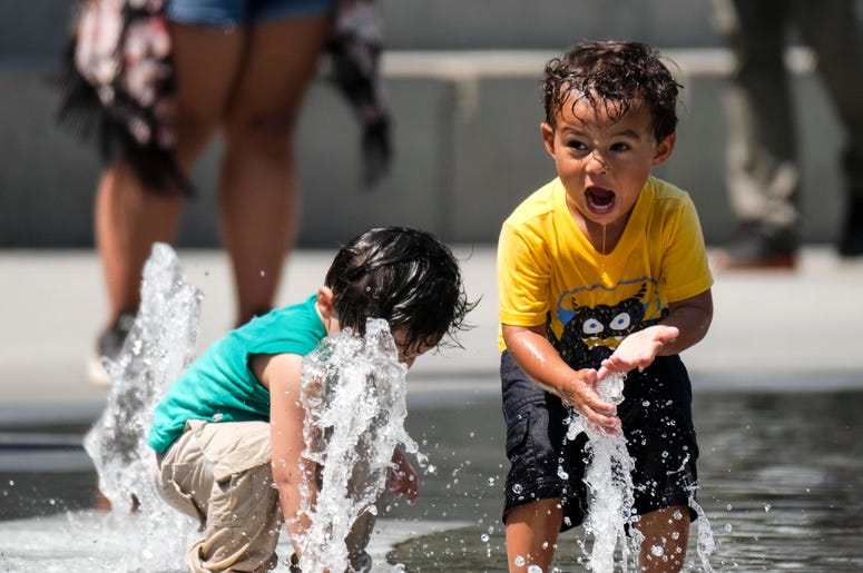 Small children play in a fountain