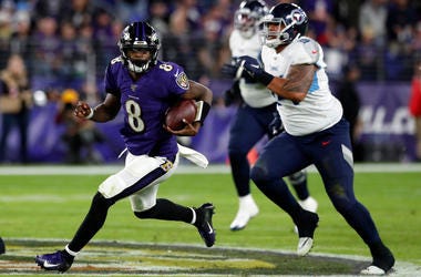 Quarterback Lamar Jackson #8 of the Baltimore Ravens carries the ball against the defense of the Tennessee Titans during the AFC Divisional Playoff game at M&T Bank Stadium on January 11, 2020 in Baltimore, Maryland