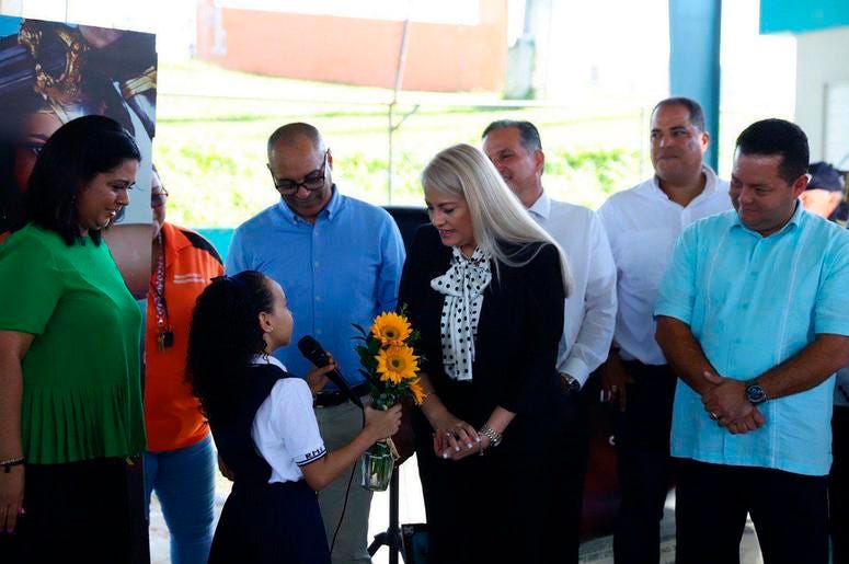 una estudiante entrega un jarrón con girasoles a la gobernadora de la isla Wanda Vázquez, durante su visita a la Escuela Ramón Marín Solá, en Guaynabo, Puerto Rico, el lunes 12 de agosto de 2019. una estudiante entrega un jarrón con girasoles a la gobernadora de la isla Wanda Vázquez, durante su visita a la Escuela Ramón Marín Solá, en Guaynabo, Puerto Rico, el lunes 12 de agosto de 2019.