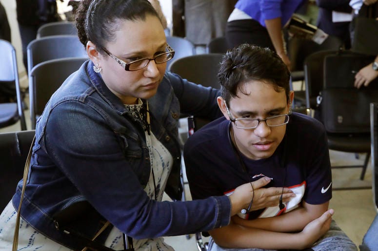 La hondureña Mariela Sánchez consuela a su hijo Jonathan, de 16 años, durante una conferencia de prensa, el lunes 26 de agosto del 2019 en Boston. La familia Sánchez viajó a Estados Unidos en busca de tratamiento médico para Jonathan, quien sufre de fibro La hondureña Mariela Sánchez consuela a su hijo Jonathan, de 16 años, durante una conferencia de prensa, el lunes 26 de agosto del 2019 en Boston. La familia Sánchez viajó a Estados Unidos en busca de tratamiento médico para Jonathan, quien sufre de fibro