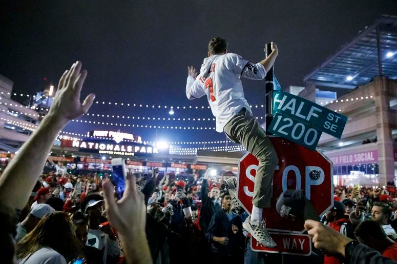 Un aficionado de los Nacionales de Washington escala un poste a las afueras de Nationals Park a primeras horas del jueves 31 de octubre de 2019, en Washington, después de que los Nacionales derrotaron a los Astros de Houston en el séptimo juego de la Seri Un aficionado de los Nacionales de Washington escala un poste a las afueras de Nationals Park a primeras horas del jueves 31 de octubre de 2019, en Washington, después de que los Nacionales derrotaron a los Astros de Houston en el séptimo juego de la Seri