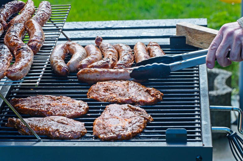 Steaks and sausages are grilled on the charcoal grill Steaks and sausages are grilled on the charcoal grill