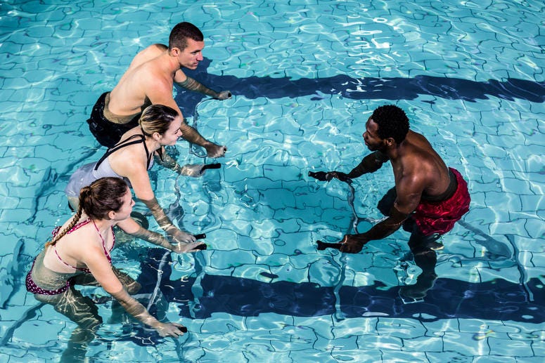 Fitness class doing aqua aerobics on exercise bikes