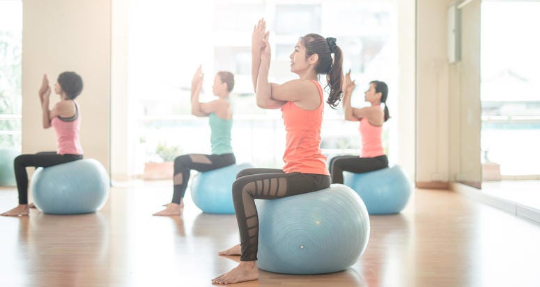 woman stretching on yoga ball in gym .do yoga