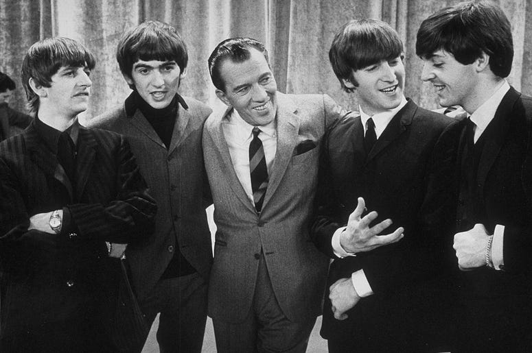 American television host Ed Sullivan smiles while standing with British rock group the Beatles on the set of his television variety series, New York, February 9, 1964. Left to right: Ringo Starr, George Harrison, Sullivan, John Lennon, Paul McCartney.
