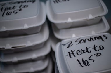 As MLK Center staff dish out prepared food into containers, reheating instructions are written on top of each meal to ensure food safety on Friday, March 27, 2020. Mlk Center Coronavirus Help Food Delivery