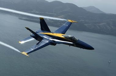 A U.S. Navy Blue Angels F/A-18 Hornet piloted by U.S. Marine Corps Major Nathan Miller flies over the San Francisco Bay