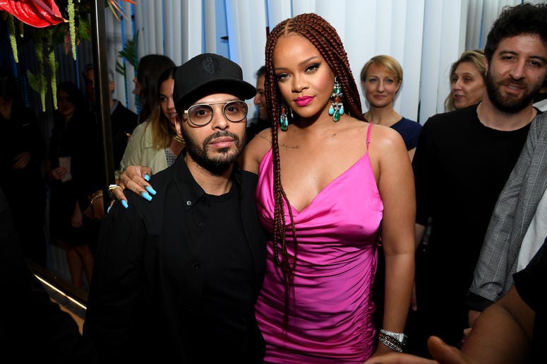 Rihanna is celebrated for her attention and celebration of real women‘s bodies. Rihanna poses in a magenta strappy dress and long burgundy braids at the New York pop-up shop event for her Fenty clothing line.
